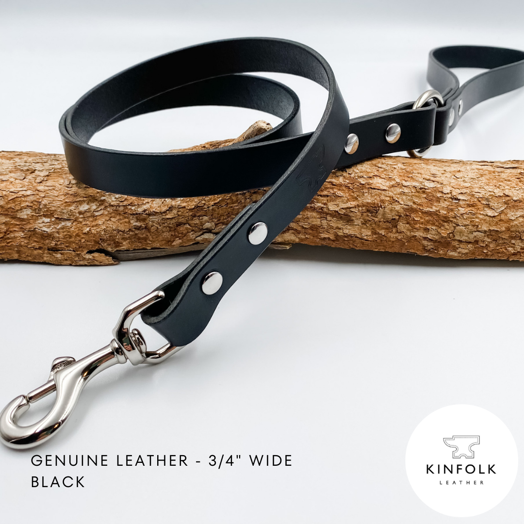 Black leather dog leash with silver hardware on a white background, featuring the Kinfolk Leather logo.