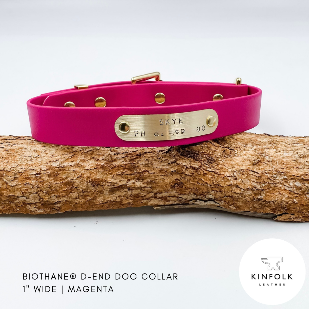 Magenta pink dog collar with gold nameplate on a wooden log against a white background, featuring the Kinfolk Leather logo.