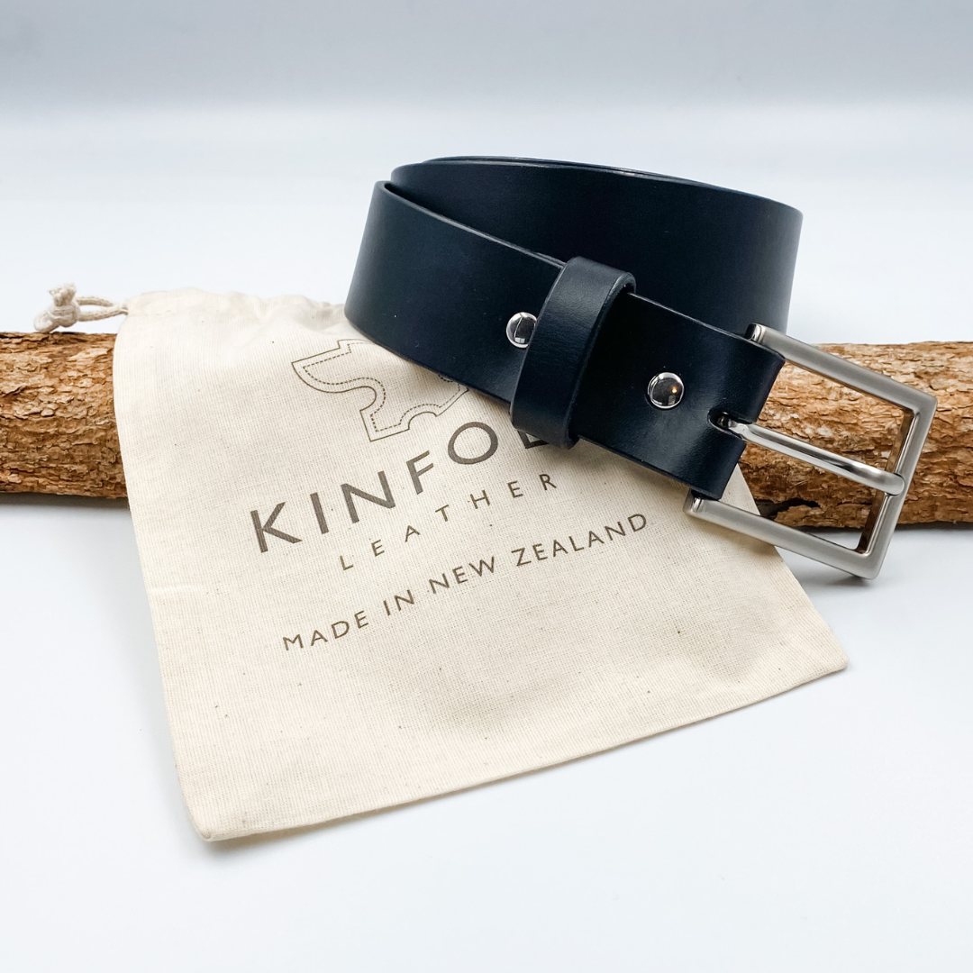 Black leather belt with silver buckle on a Kinfolk Leather branded pouch.