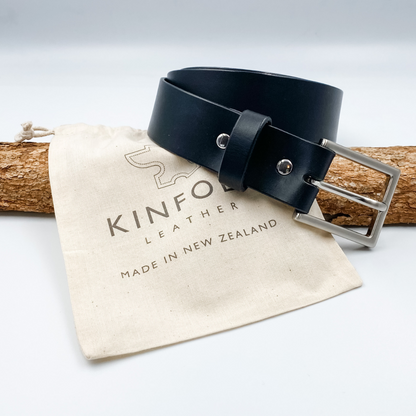 Black leather belt with silver buckle on a Kinfolk Leather branded pouch.