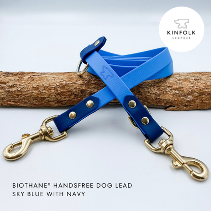 Blue and navy biotthane handsfree dog lead with gold hardware on a white background, featuring the Kinfolk Leather logo.